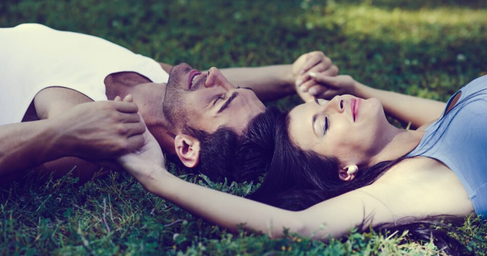 Happy Smiling Couple Laying On Green Grass