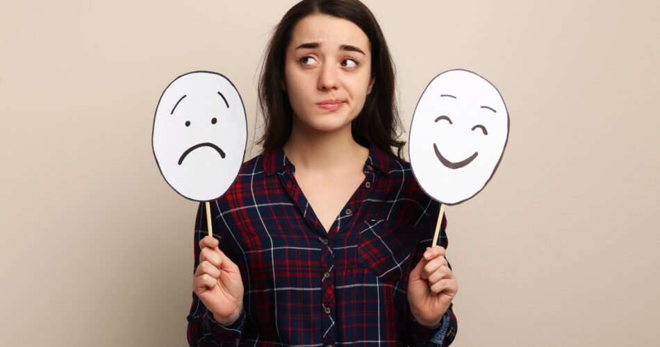 Woman With Sad And Happy Paper Faces On Beige Background